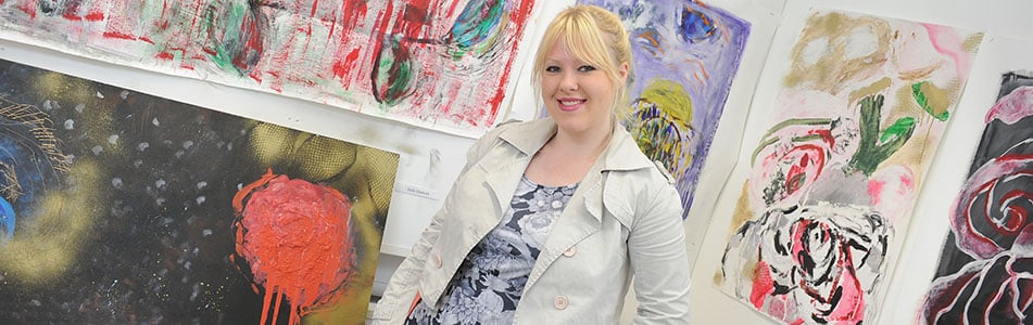 student posing by her art